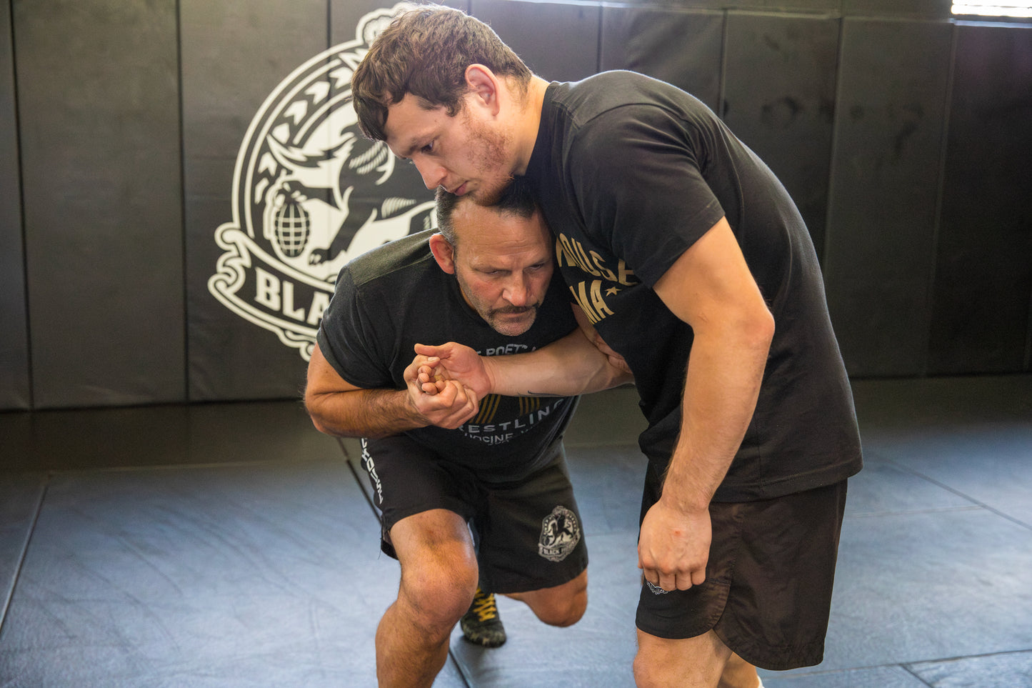 A photo of a wrestling coach demonstrating Wrestling