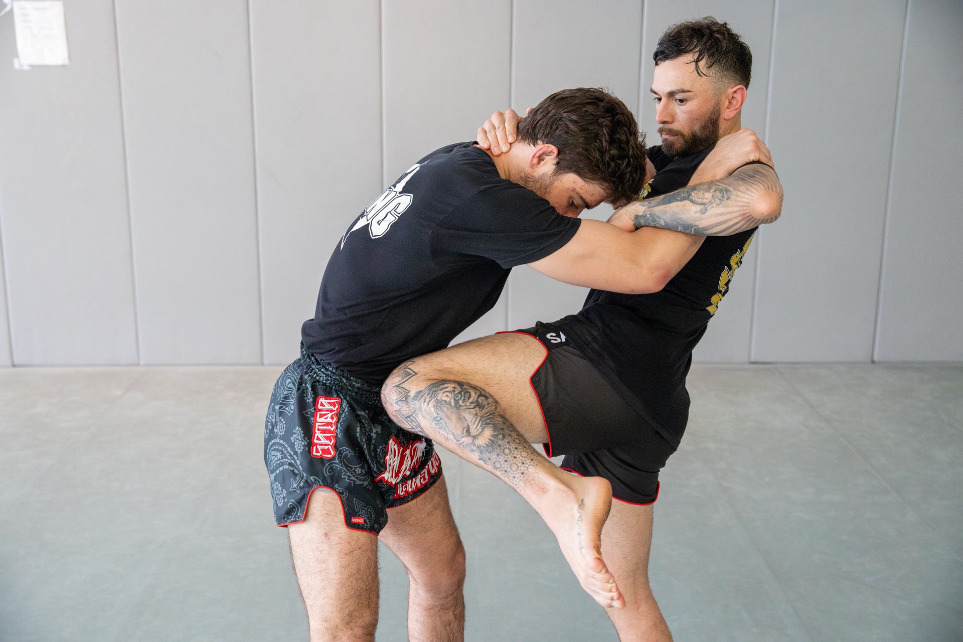 a photo of two Muay Thai fighters training in the clinch