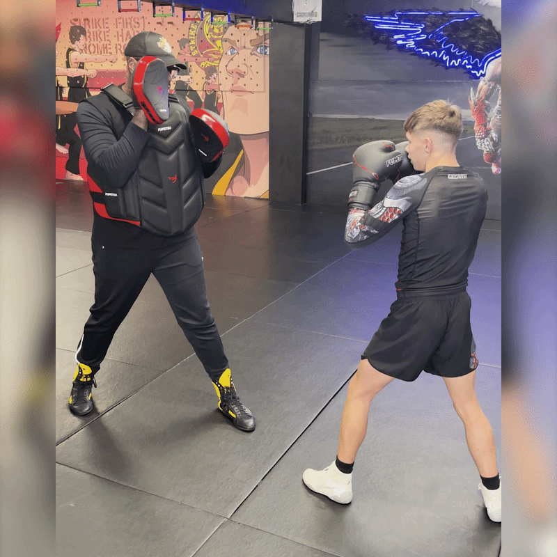 Boxing padwork with a coach and a young fighter