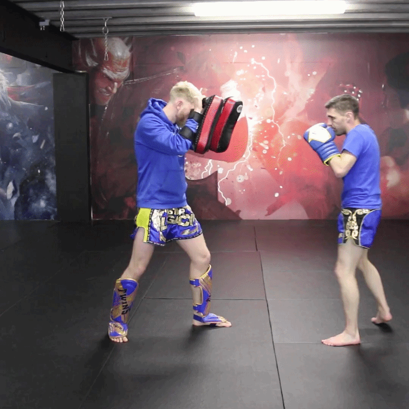 A GIF of a Muay Thai fighter training on the pads with a partner athlete