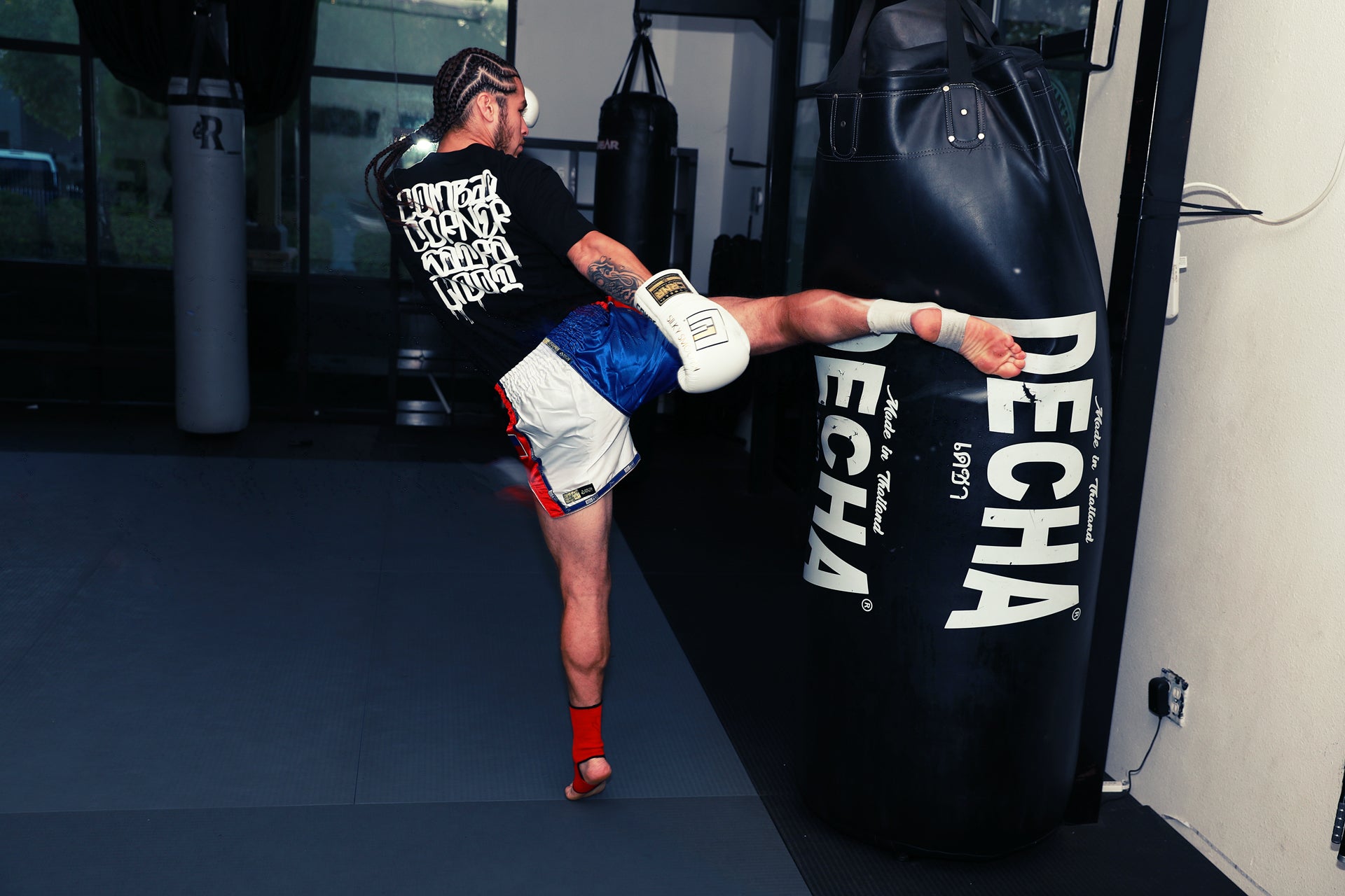 A photo of Eddie demonstrating a kick on the heavy bag