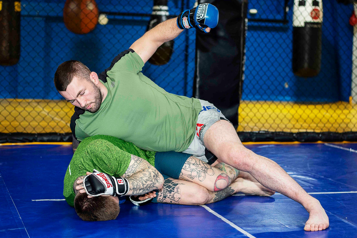 a fighter demonstrating ground and pound techniques in a MMA gym