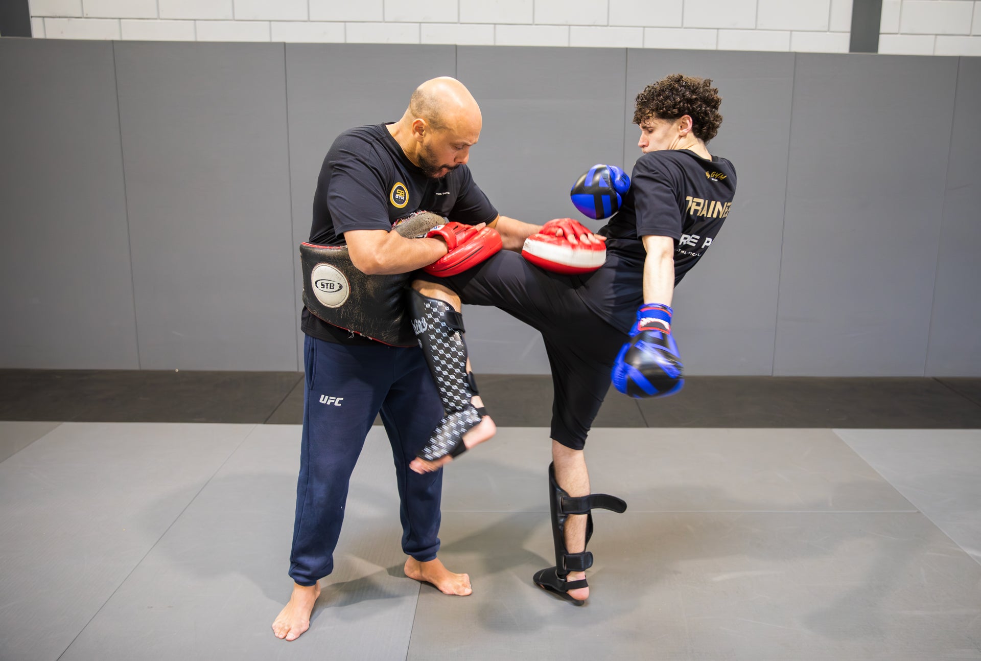 A fighter training with his coach in a martial arts gym