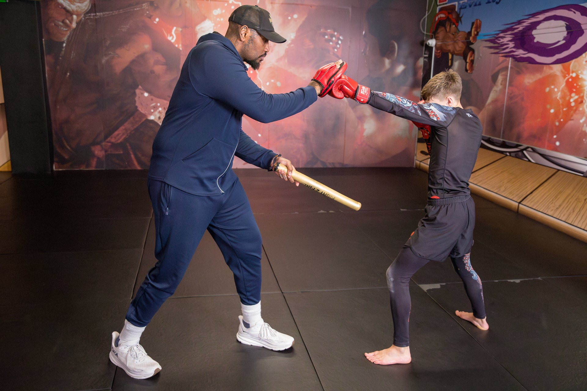 A photo of a boxing coach demonstrating pad work