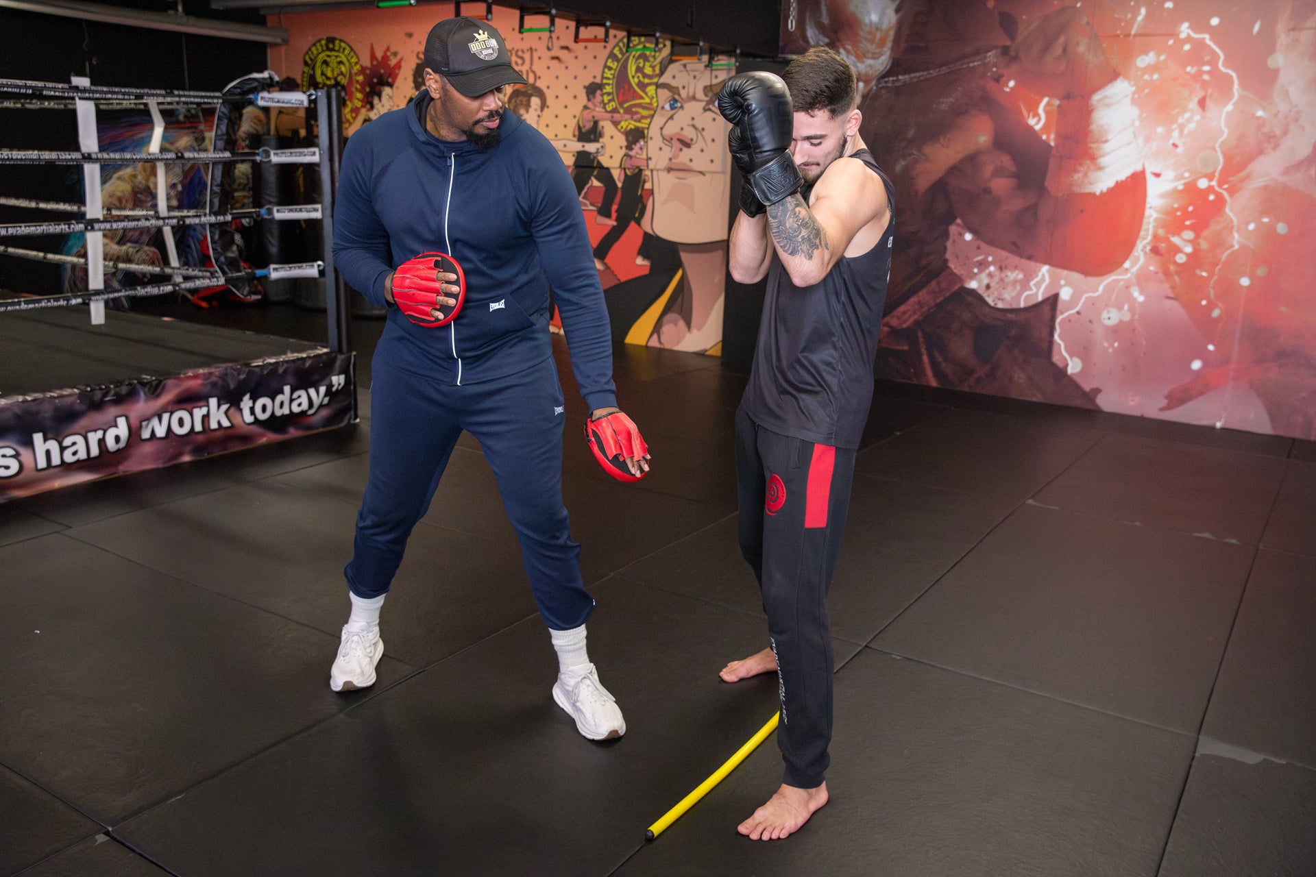 A photo of a boxing coach giving details on footwork