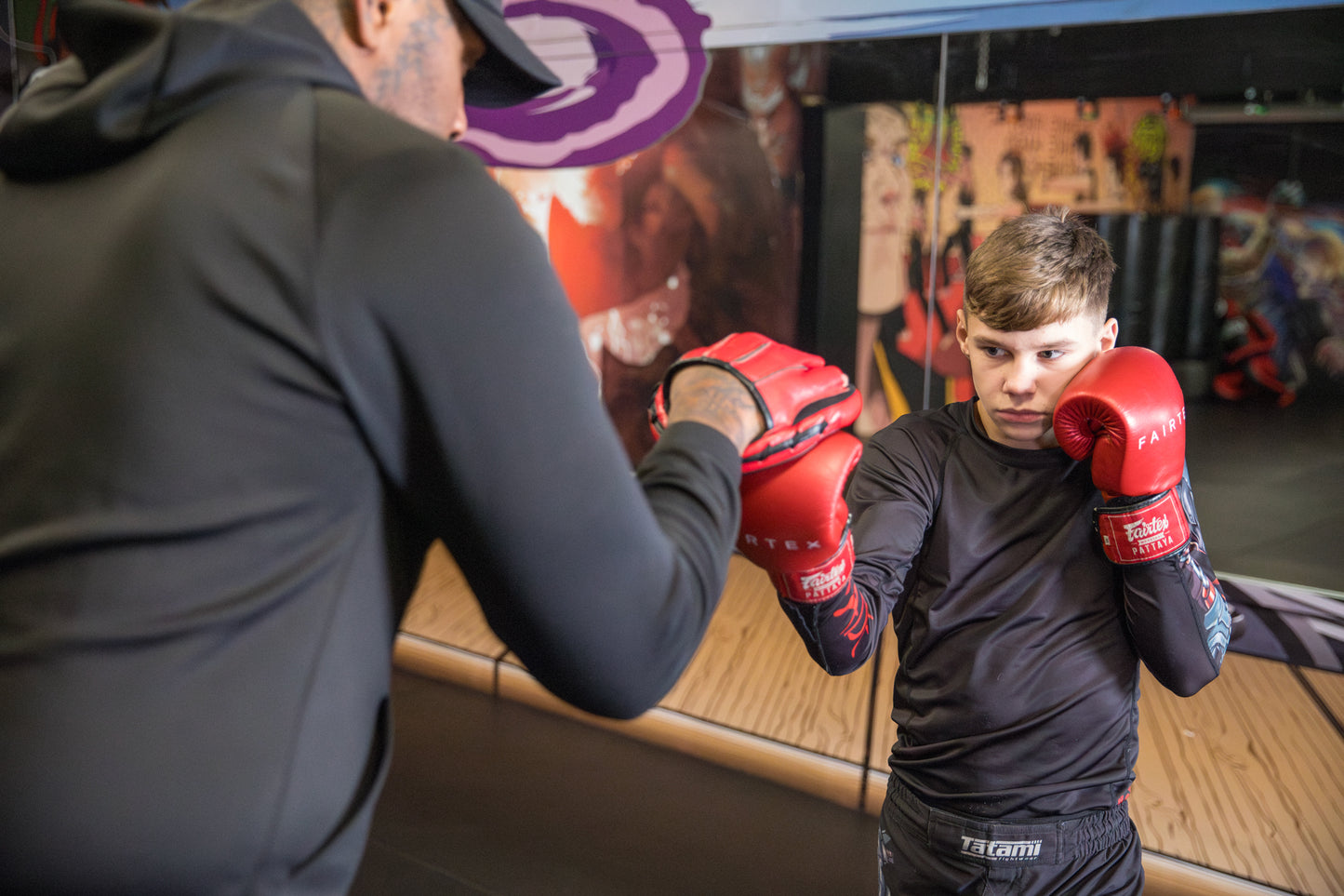 a young fighter training with his coach