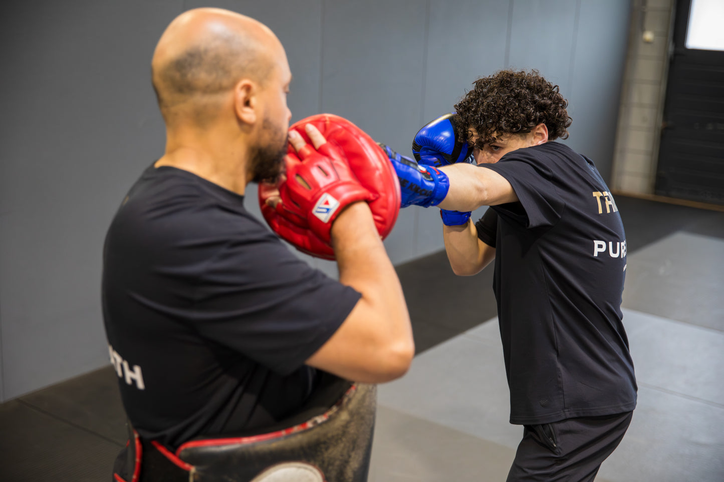 A fighter throwing a jab onto his coaches focus pad