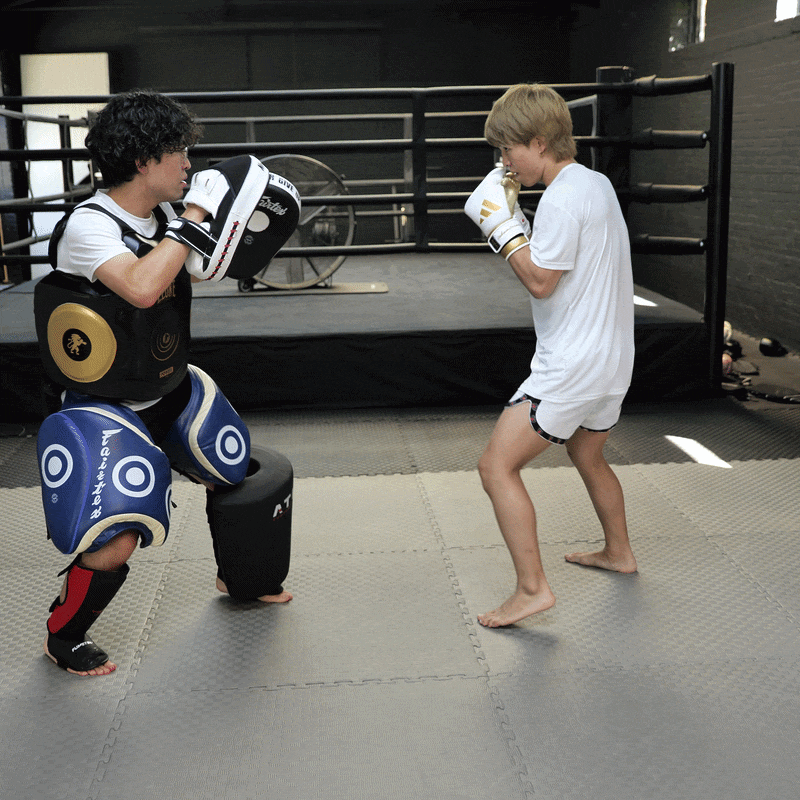 A GIF of a coach holding pads for a fighter in training