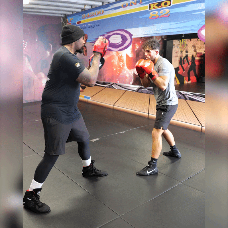 A fighter training with his boxing coach in the gym