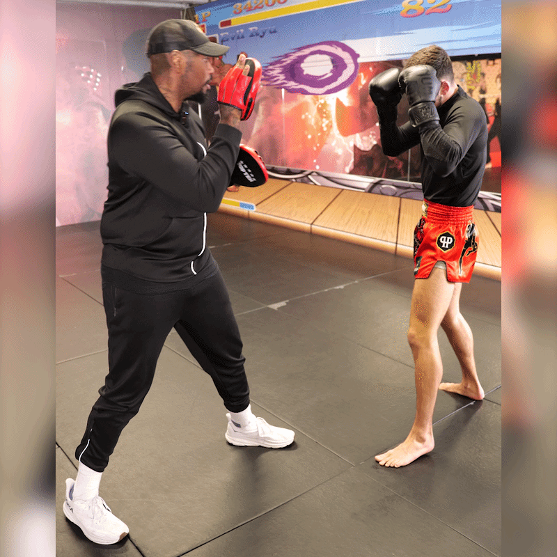 A fighter training on the pads with his coach