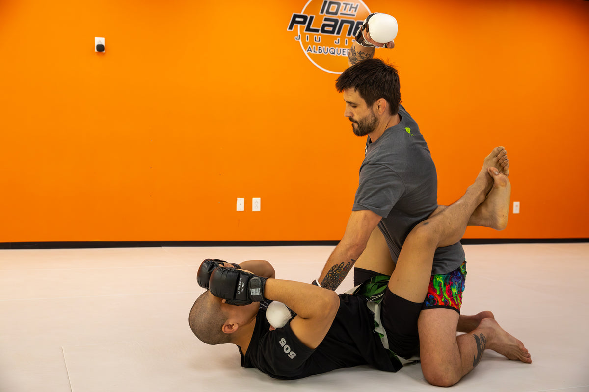 A fighter posturing up in guard in order to deliver ground and pound strikes in MMA