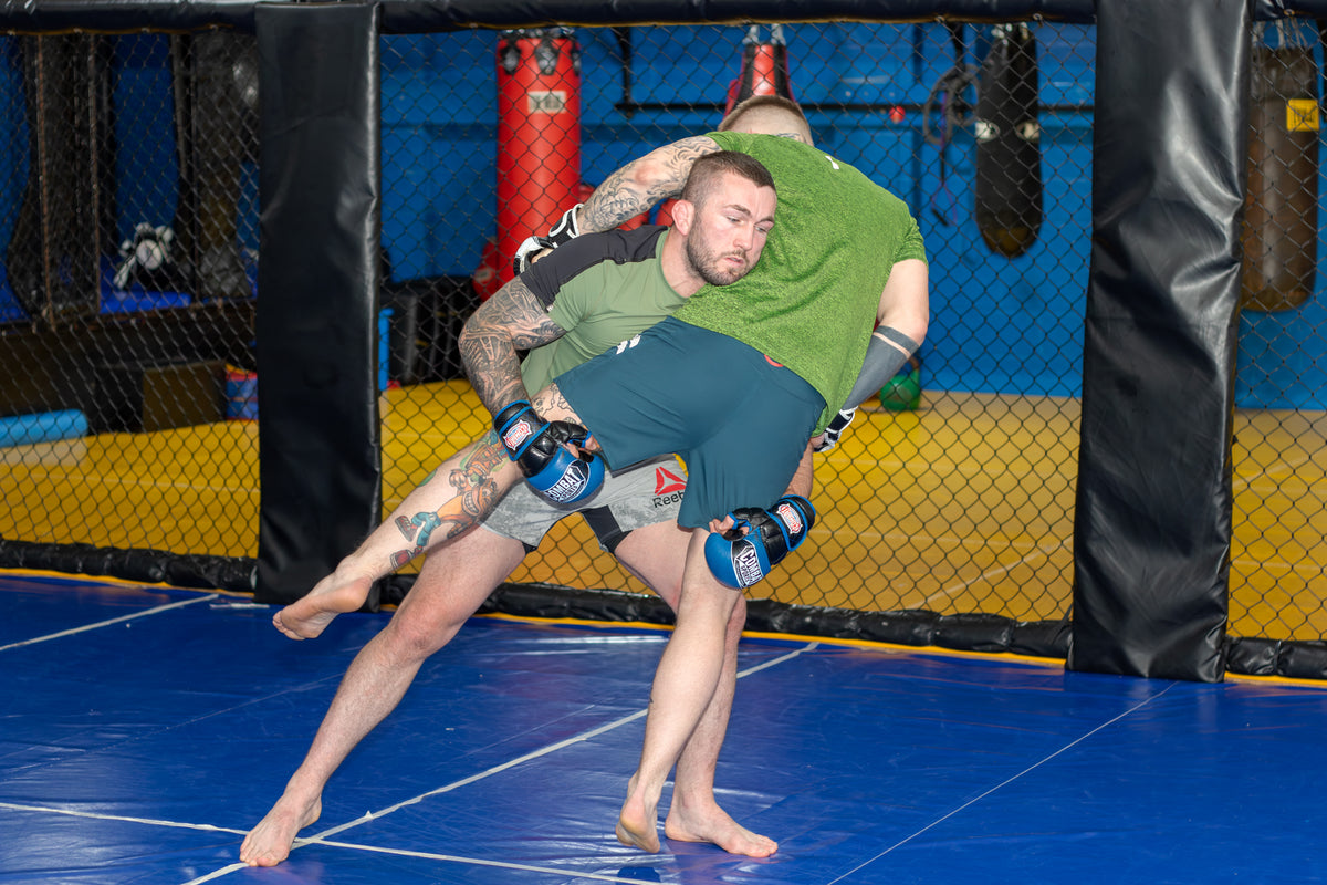 Two fighters training together in a martial arts gym