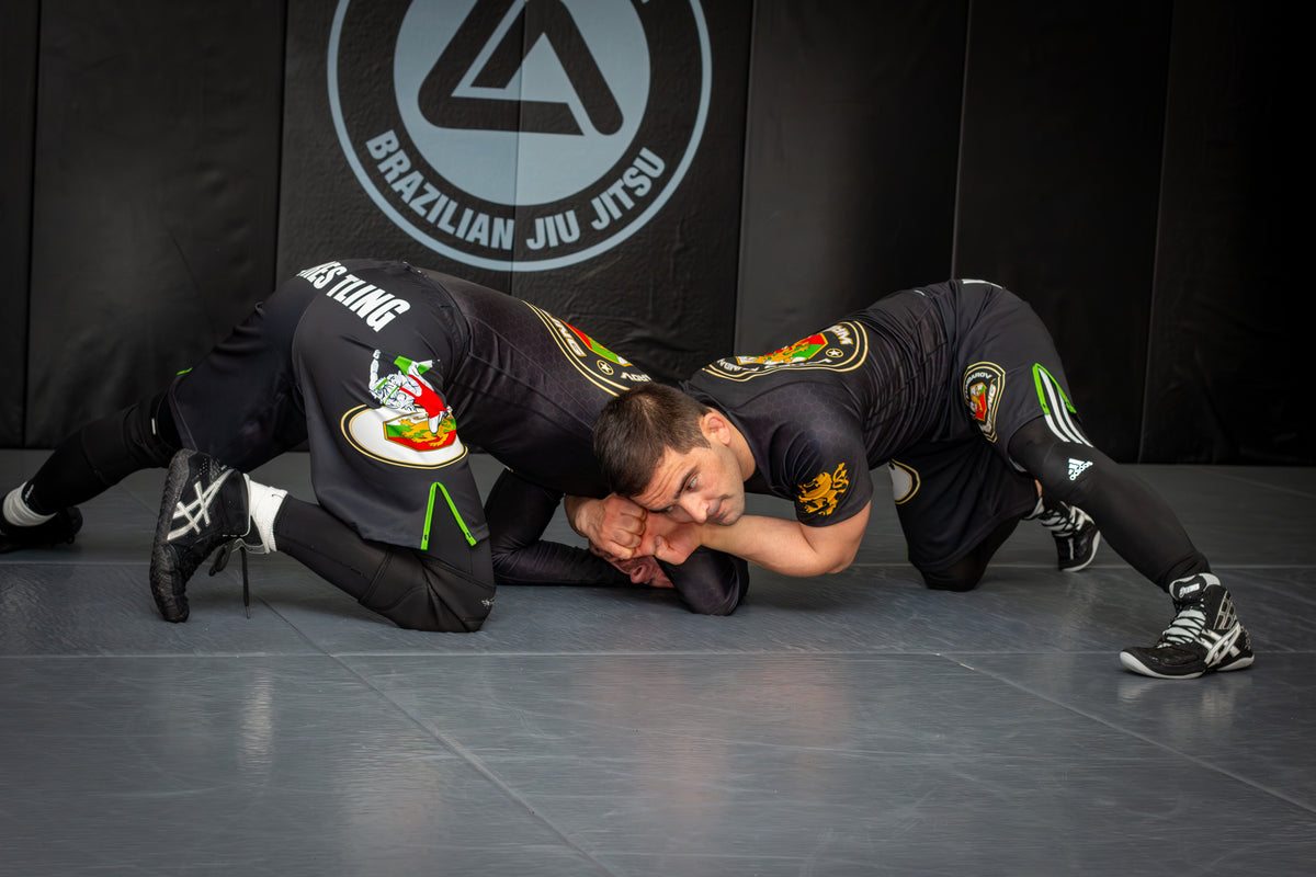 two athletes training grappling drills together in a martial arts gym