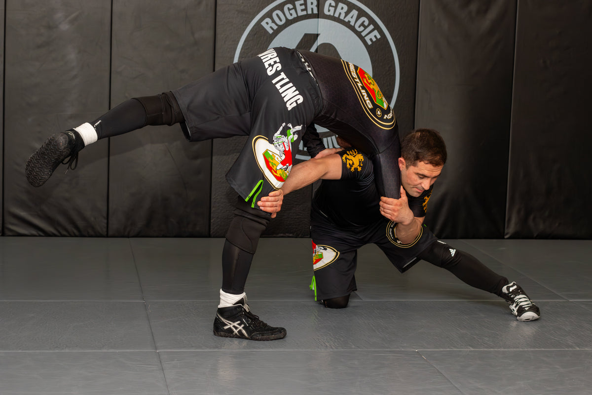 two athletes training grappling drills together in a martial arts gym
