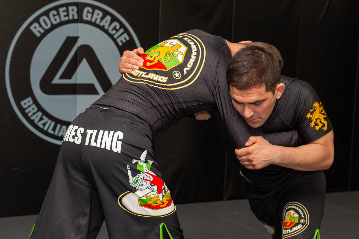 two athletes training grappling drills together in a martial arts gym