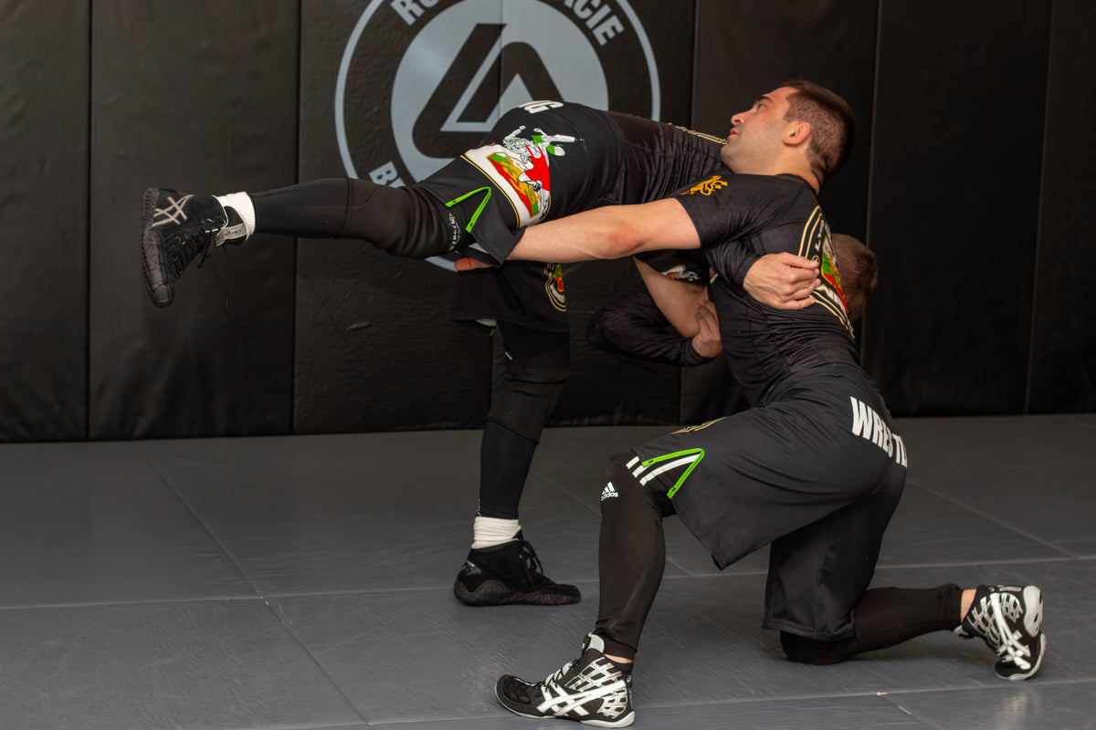 two athletes training grappling drills together in a martial arts gym